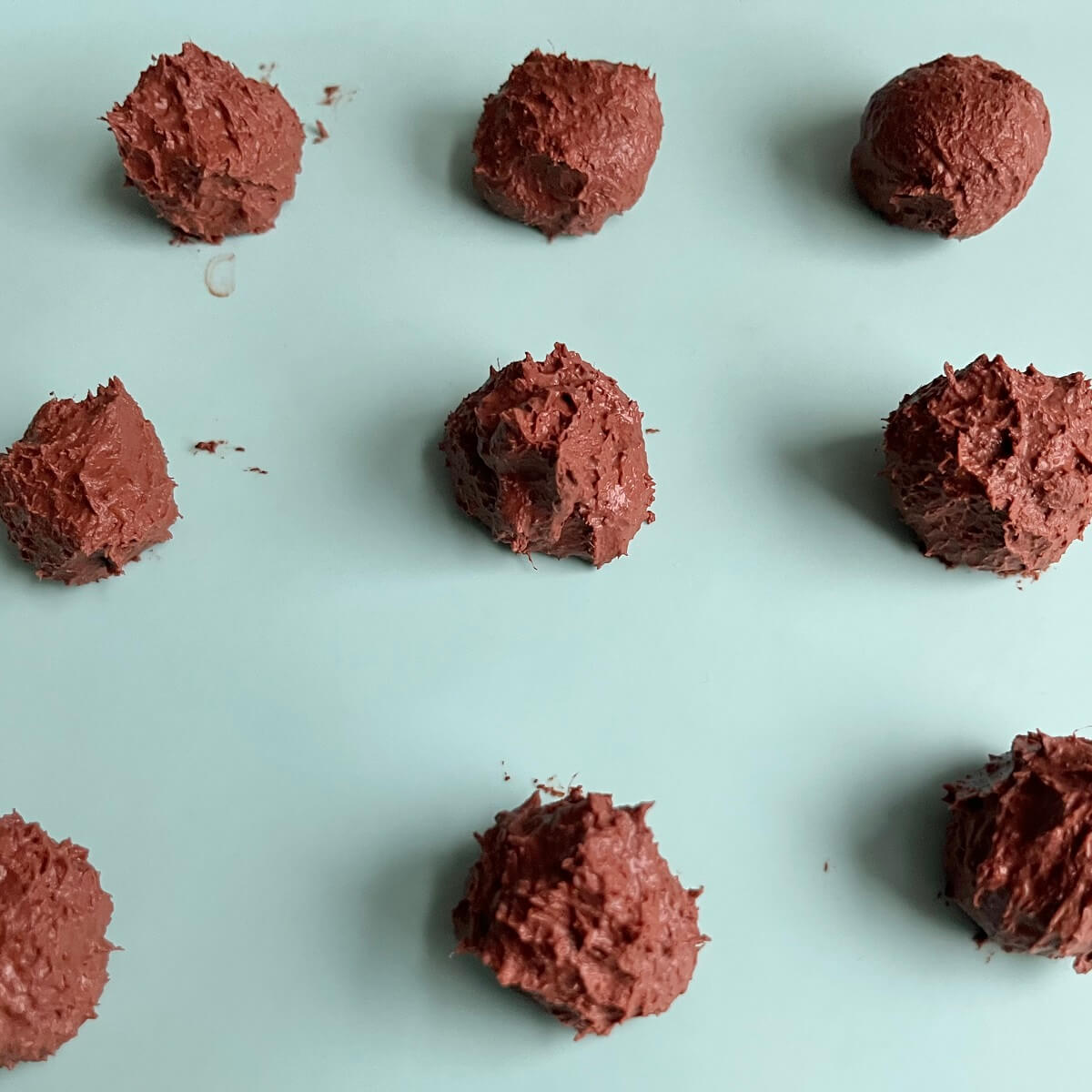 Chocolate mango balls on a silicone baking mat.