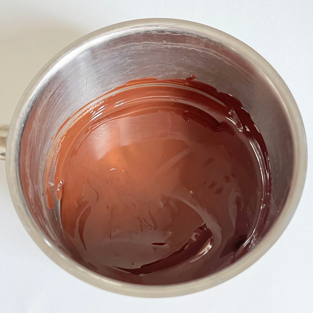 Dark chocolate melting in a steel pot.