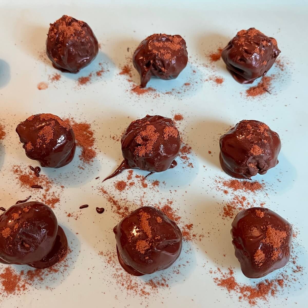 Truffles dusted with pumpkin spice on a silicone baking mat.