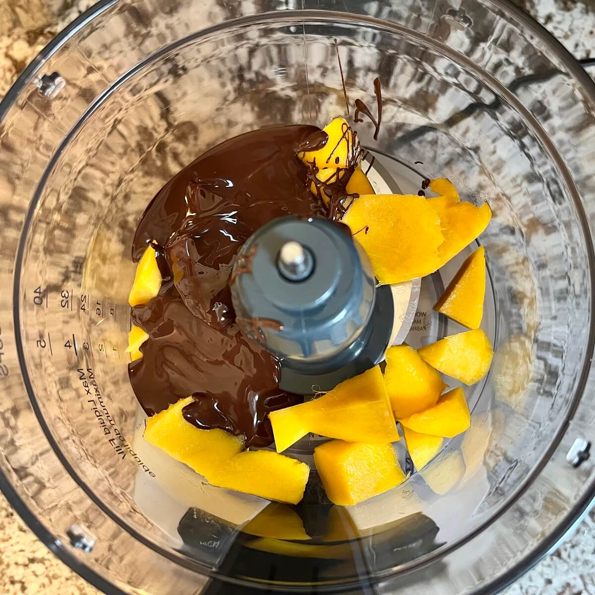 Ingredients for mango chocolates in a food processor.