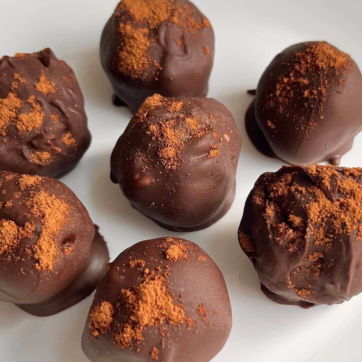 Pumpkin chocolates on a white plate.