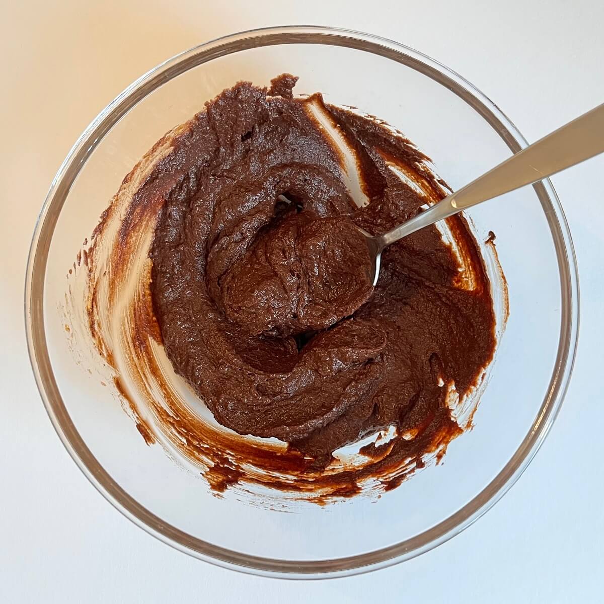 Ingredients for pumpkin spice truffles being mixed in a glass bowl.