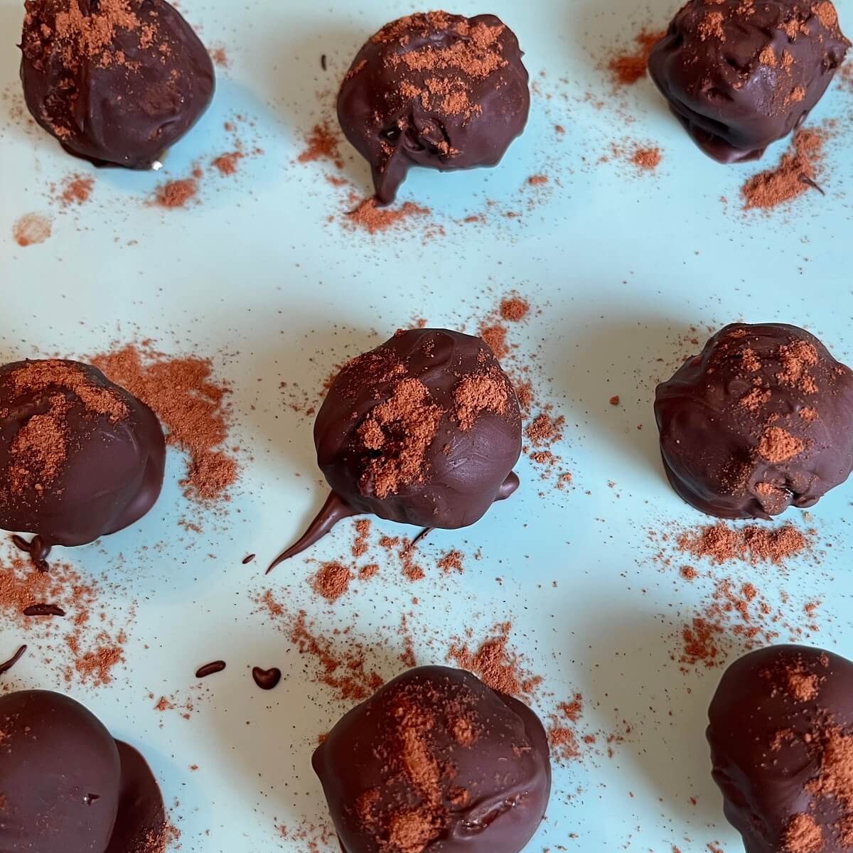 Pumpkin truffles on a silicone baking mat.