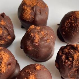 Pumpkin truffles on a white plate.