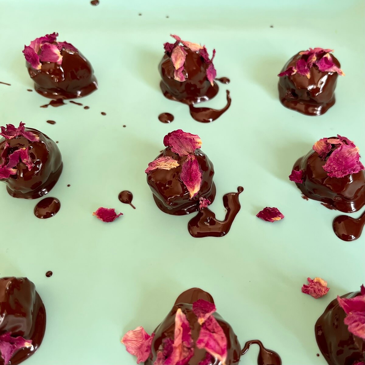 Rose petal chocolates on a silicone baking mat.