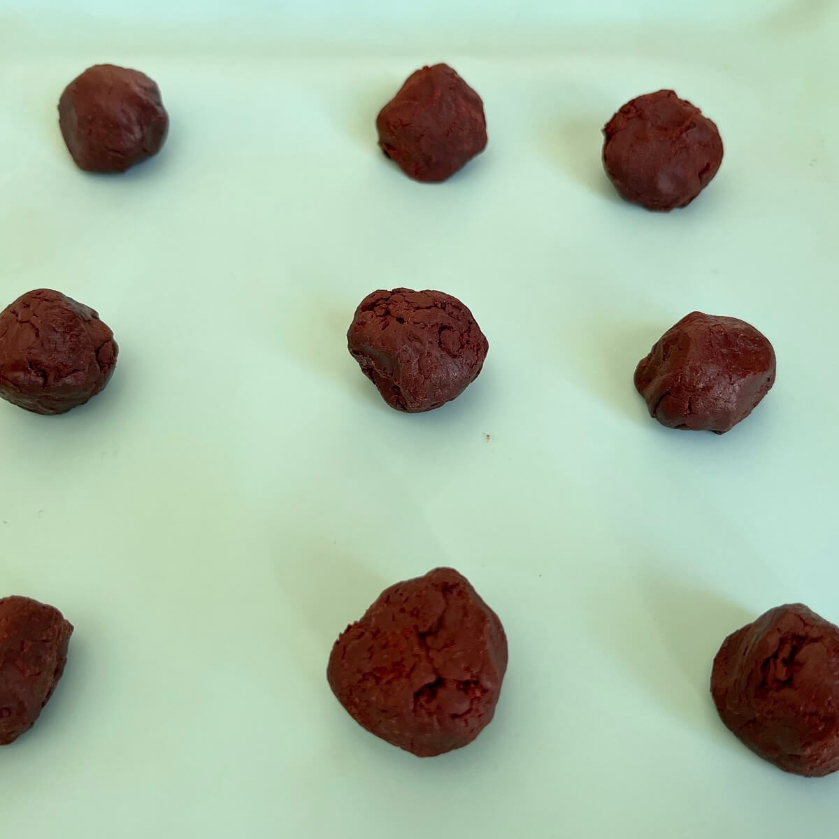 Rose water chocolate balls on a silicone baking mat.