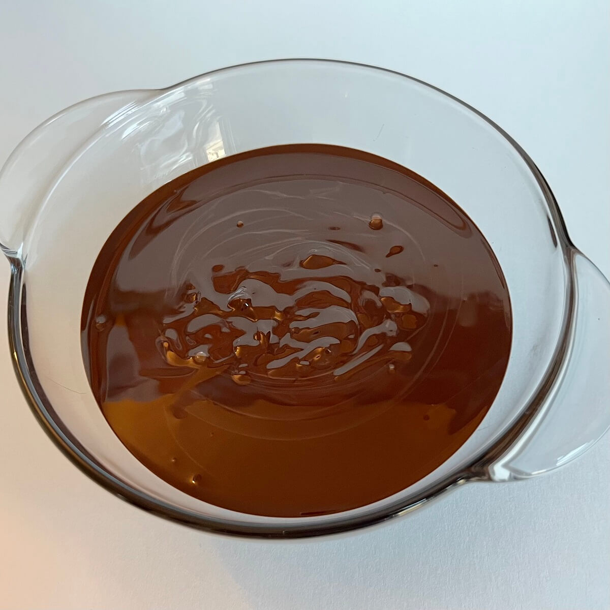 Melted warm dark chocolate in a bowl.