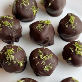 Lime chocolate truffles on a white plate.