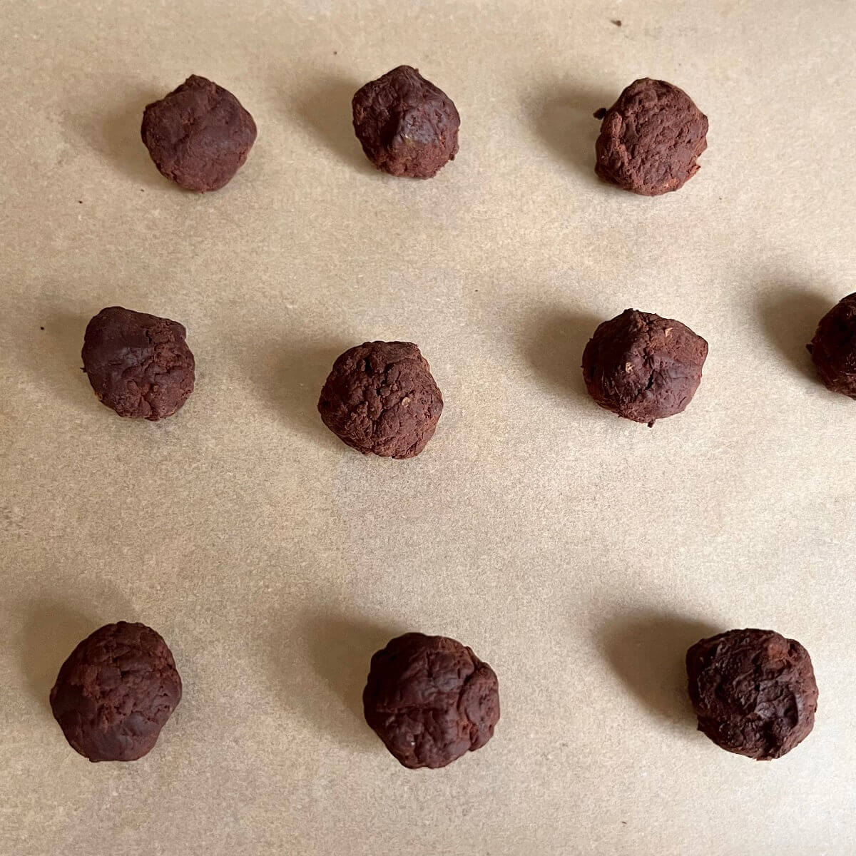 Lime and chocolate balls on a piece of parchment paper.