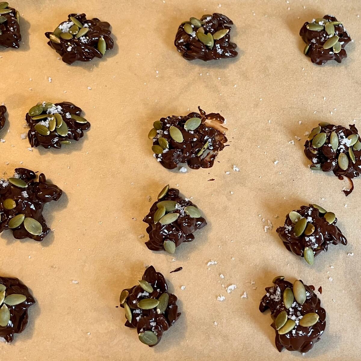 Pumpkin seed clusters on a sheet pan lined with parchment paper.