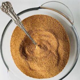 Coconut sugar in a bowl with a metal spoon.