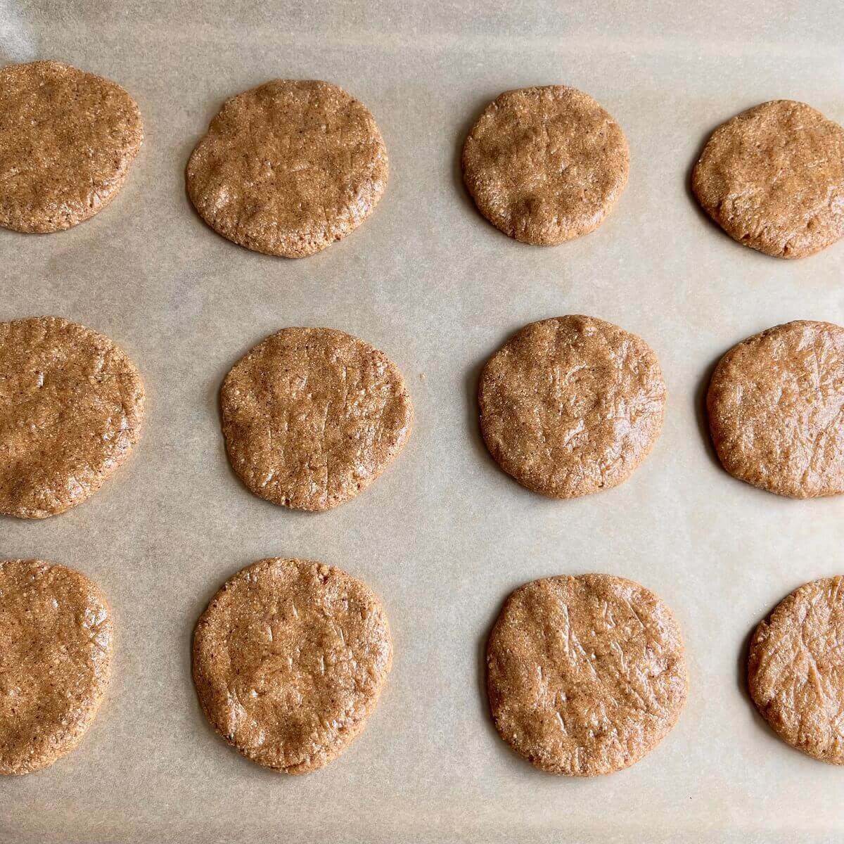 Freshly baked cornbread cookies on a sheet pan lined with parchment paper.