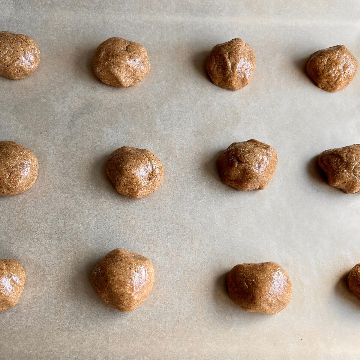 Corn cookie dough balls on a sheet pan lined with parchment paper.
