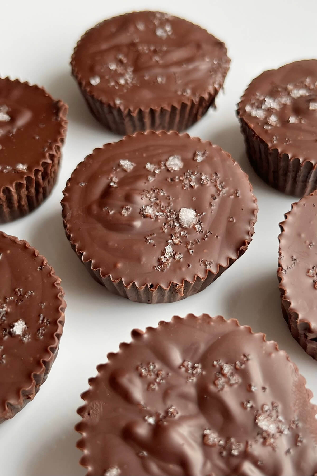Dark chocolate peanut butter cups on a white plate.