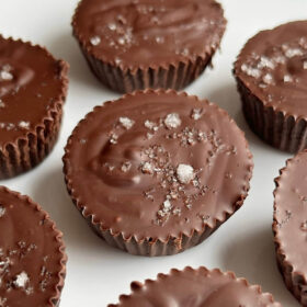 Peanut butter cups sprinkled with sea salt on a white plate.