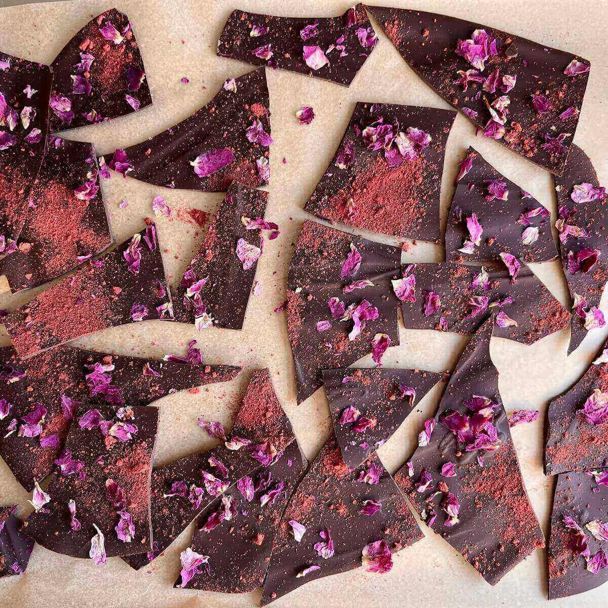 Shards of chocolate bark on a sheet pan lined with parchment paper.