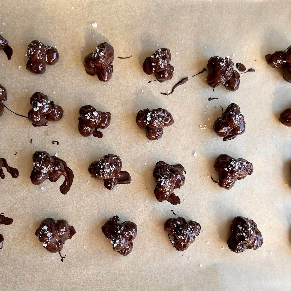 Hazelnut chocolate clusters on a sheet pan lined with parchment paper.