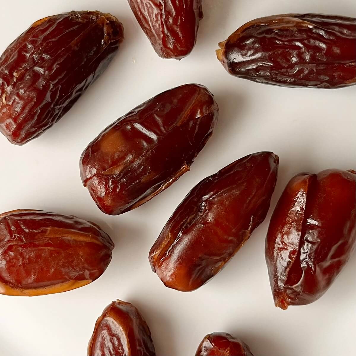 Deglet Noor dates on a white platter.