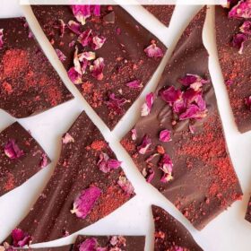 Dark chocolate bark topped with dried rose petals and strawberry powder.
