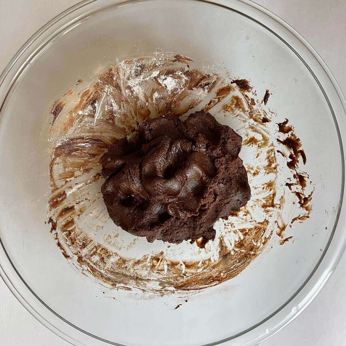 Carob dough in a glass mixing bowl.