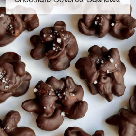 Chocolate coated cashews on a white plate.