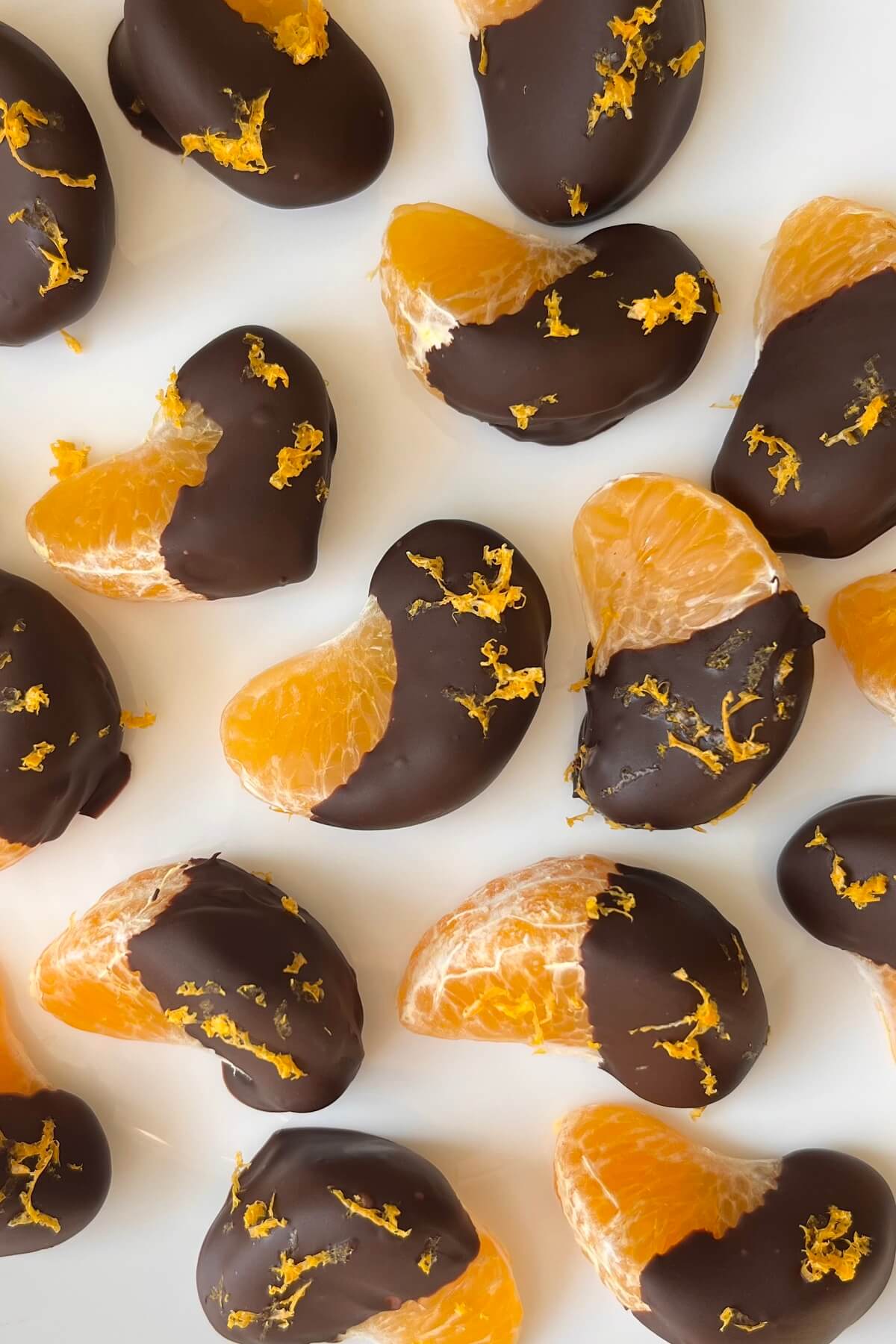 Chocolate coated oranges sprinkled with zest.