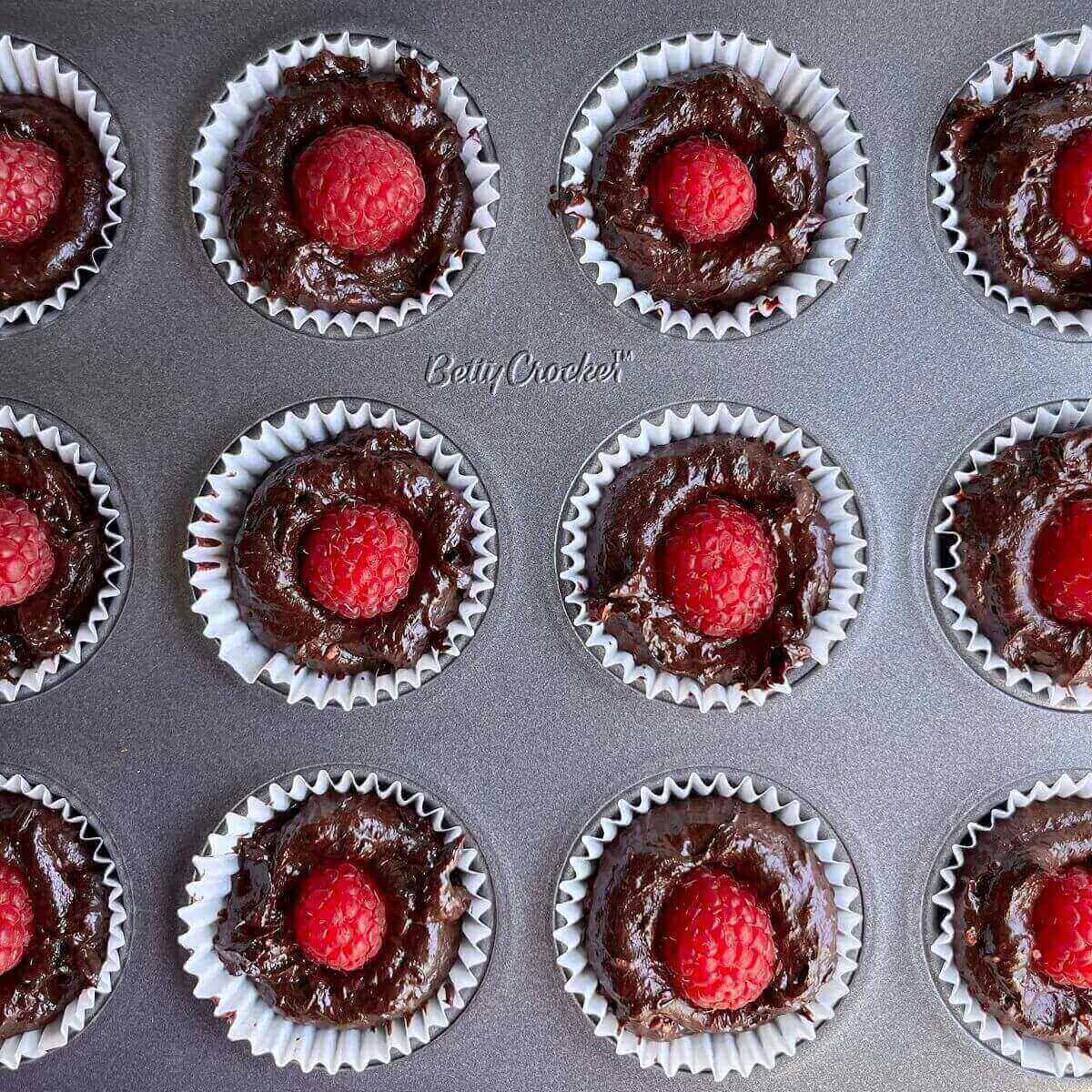 Chocolate raspberry treats in a mini muffin pan.