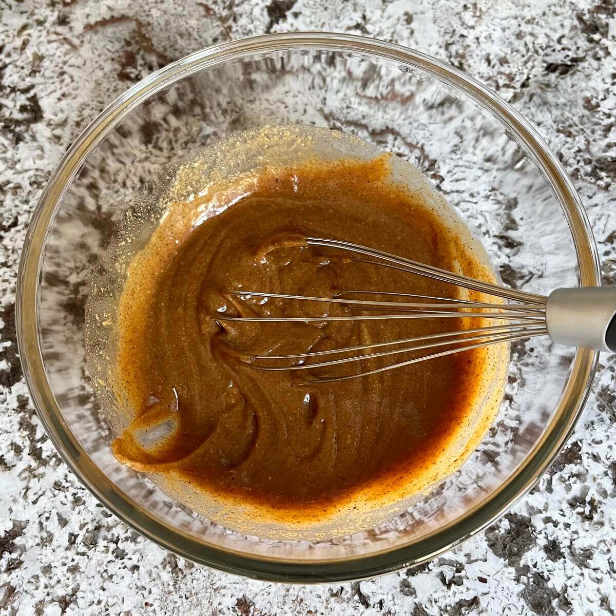 Wet ingredients for protein cookies in a glass bowl.