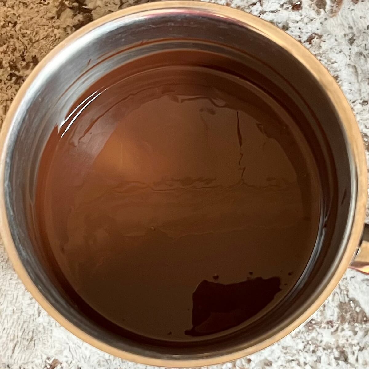 Dark chocolate melted in a steel pot.