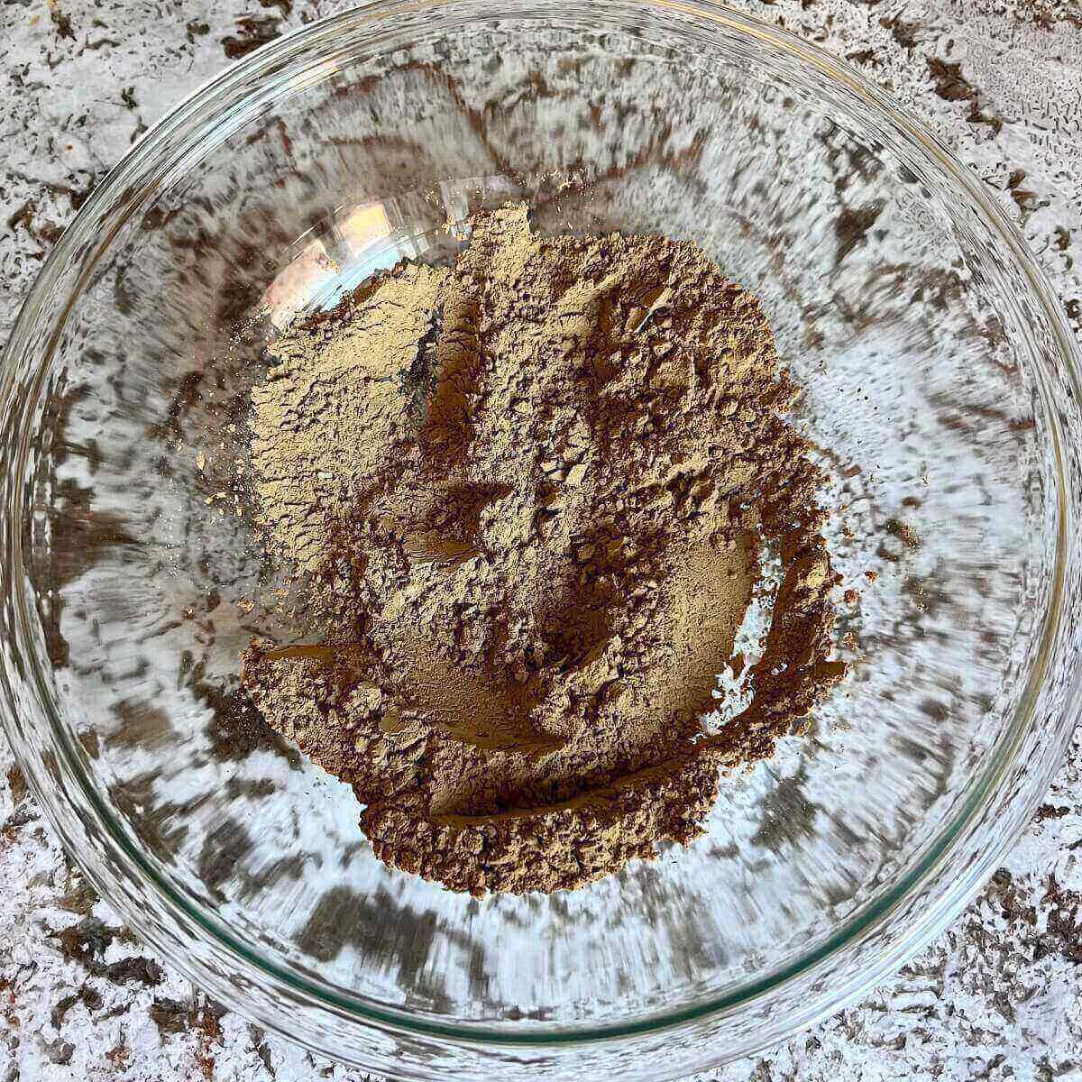 Dry ingredients for protein cookies in a glass mixing bowl.