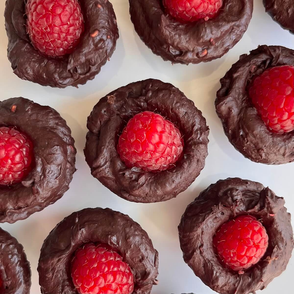 Raspberry chocolates on a white plate.