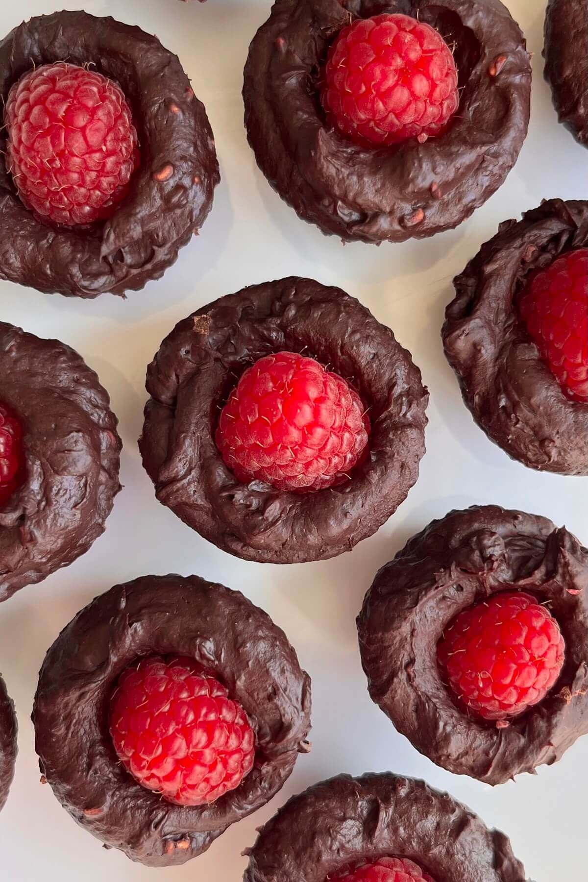 Raspberry chocolate confections on a white plate.