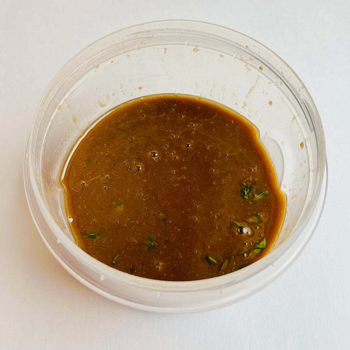Balsamic dressing in a plastic container.
