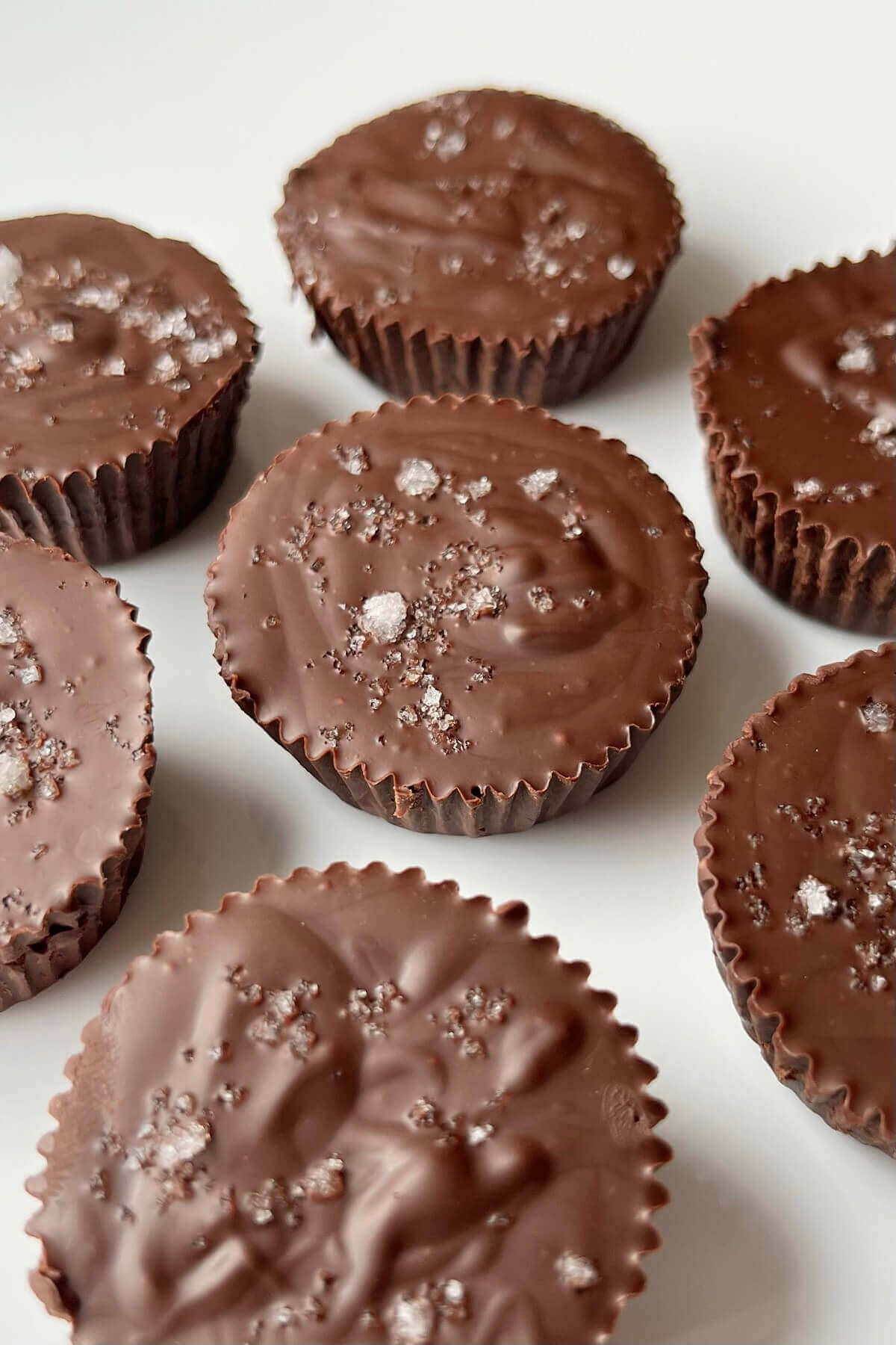 Dark chocolate truffle peanut butter cups on a white plate.