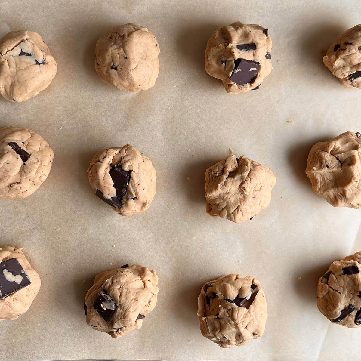 Pea protein dough balls on a sheet pan lined with parchment paper.