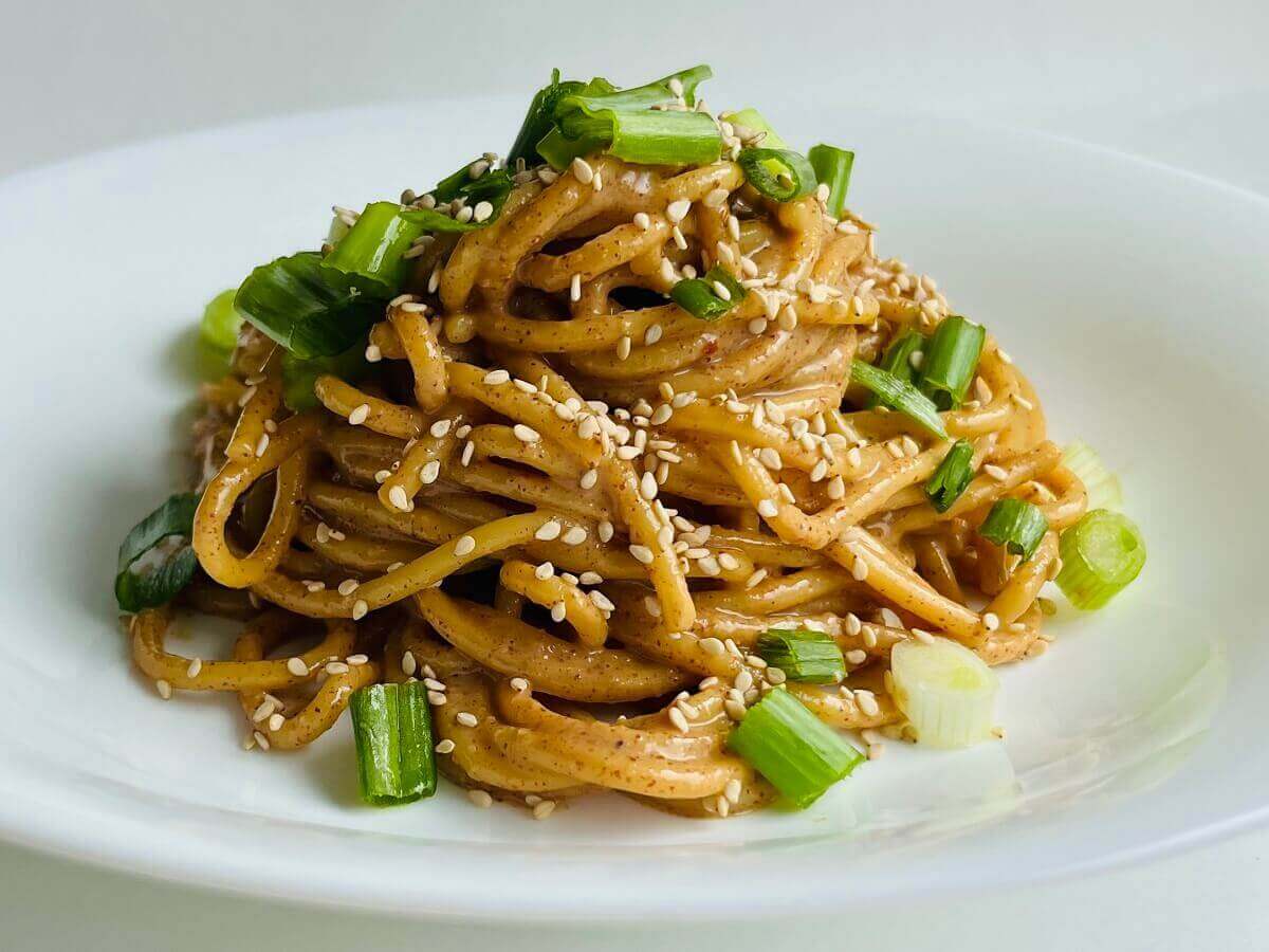 Almond butter pasta in a white bowl.