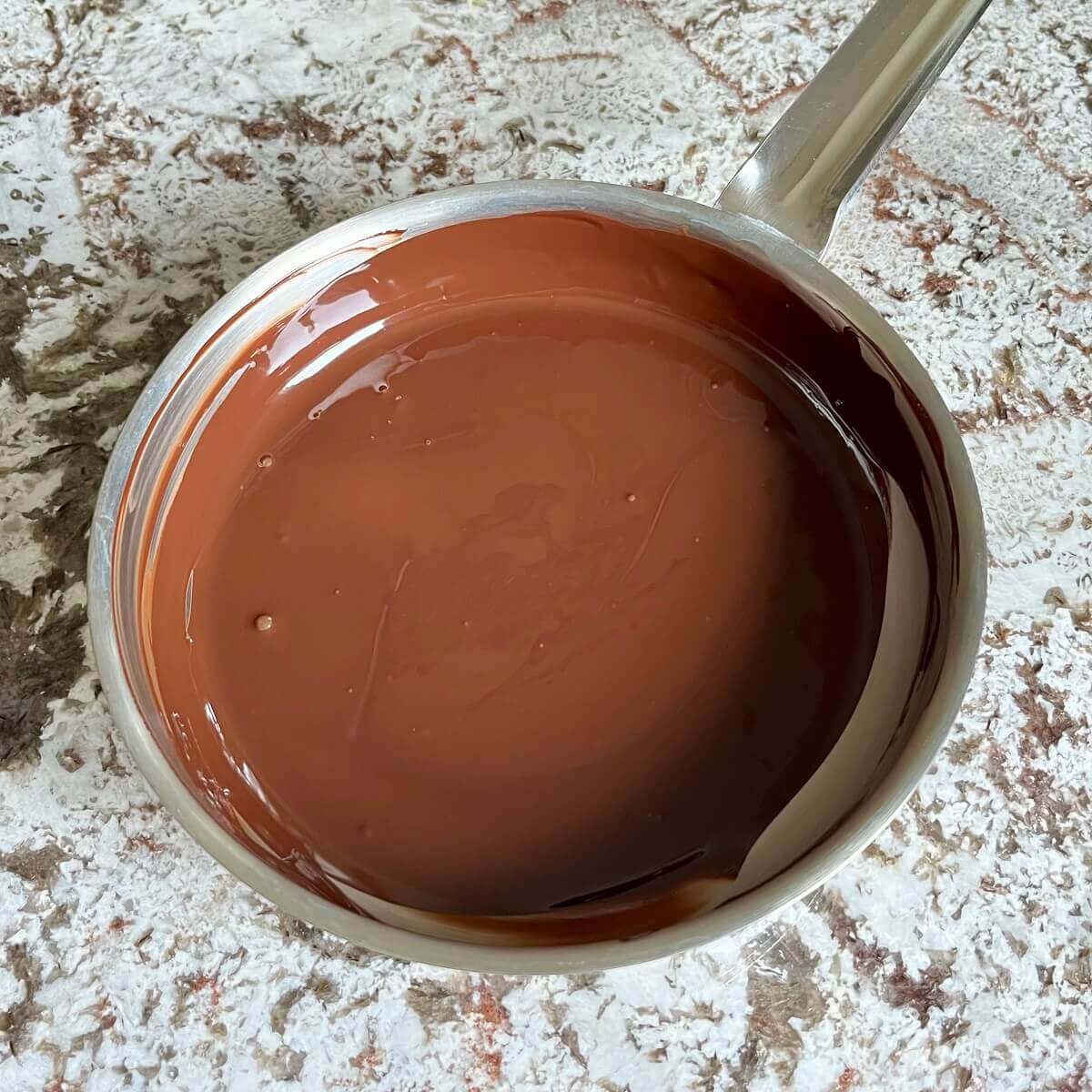 Melted chocolate for pudding in a steel pan.