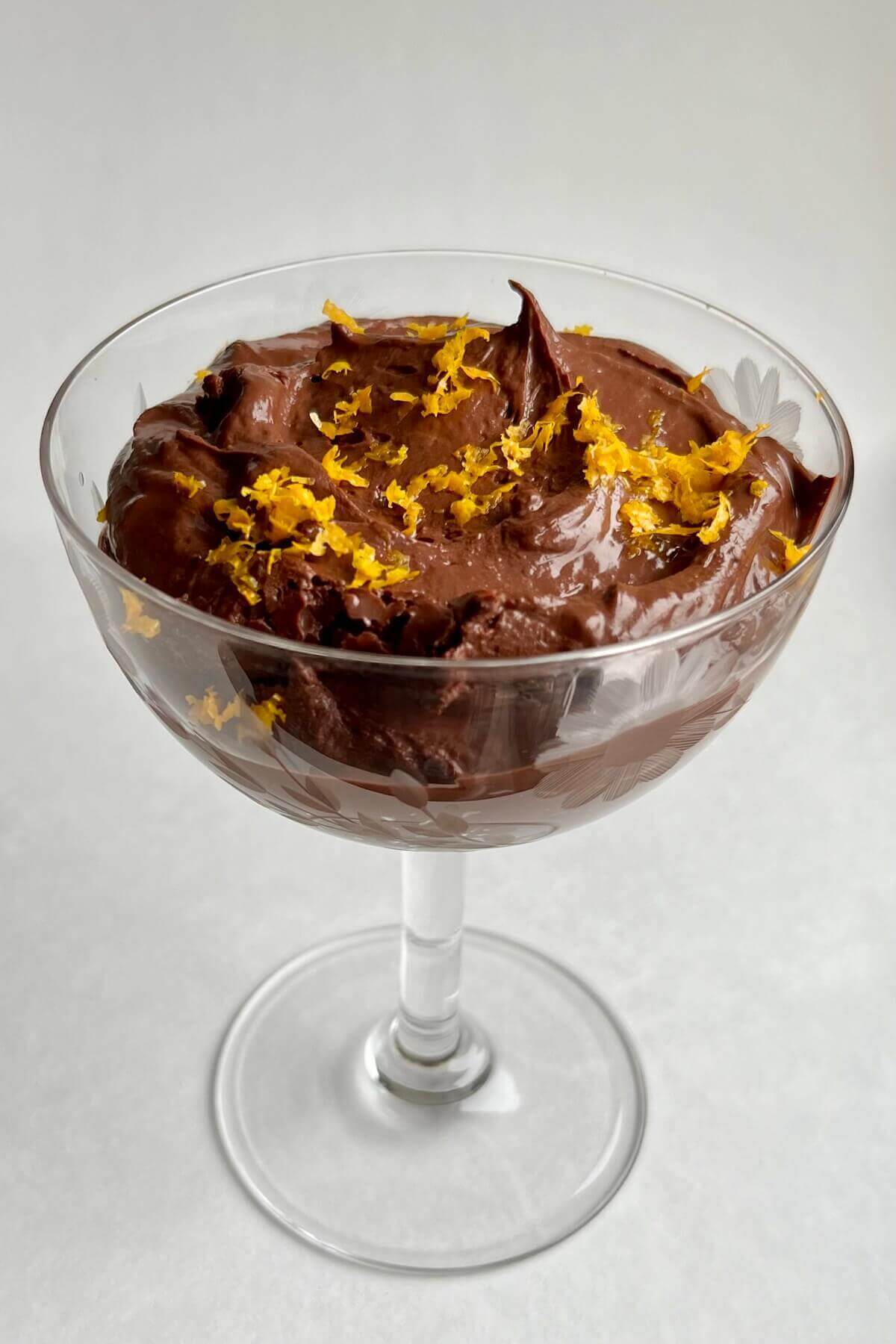 Pudding made from oranges and chocolate in a vintage glass dish.