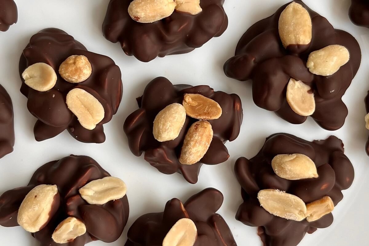 Peanut chocolate clusters on a white plate.