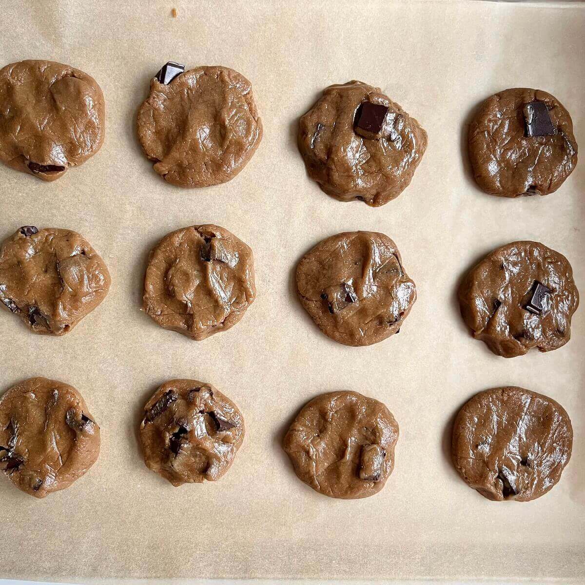 Raw sunflower cookies on a baking sheet lined with parchment paper.