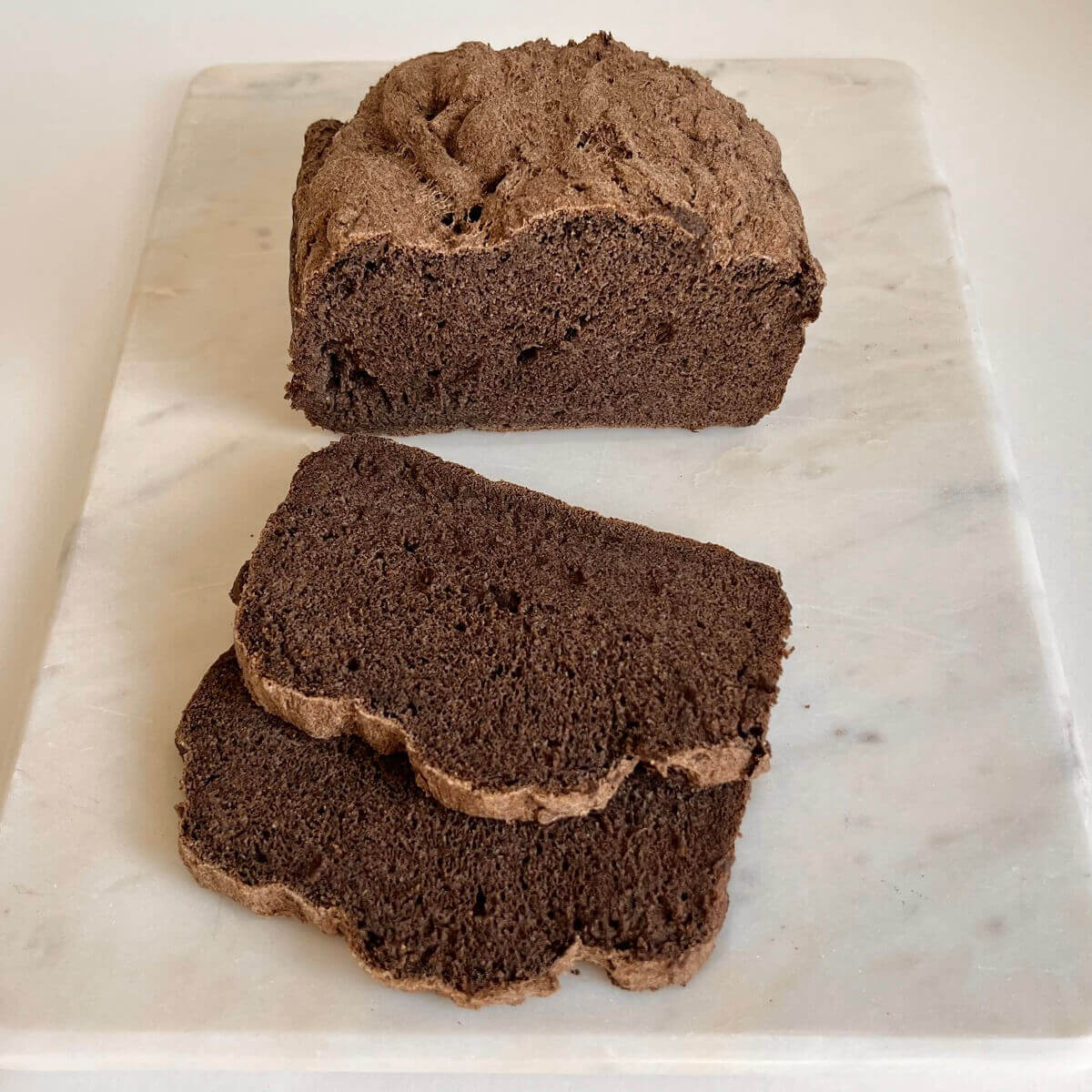Gluten-free buckwheat bread on a marble cutting board.