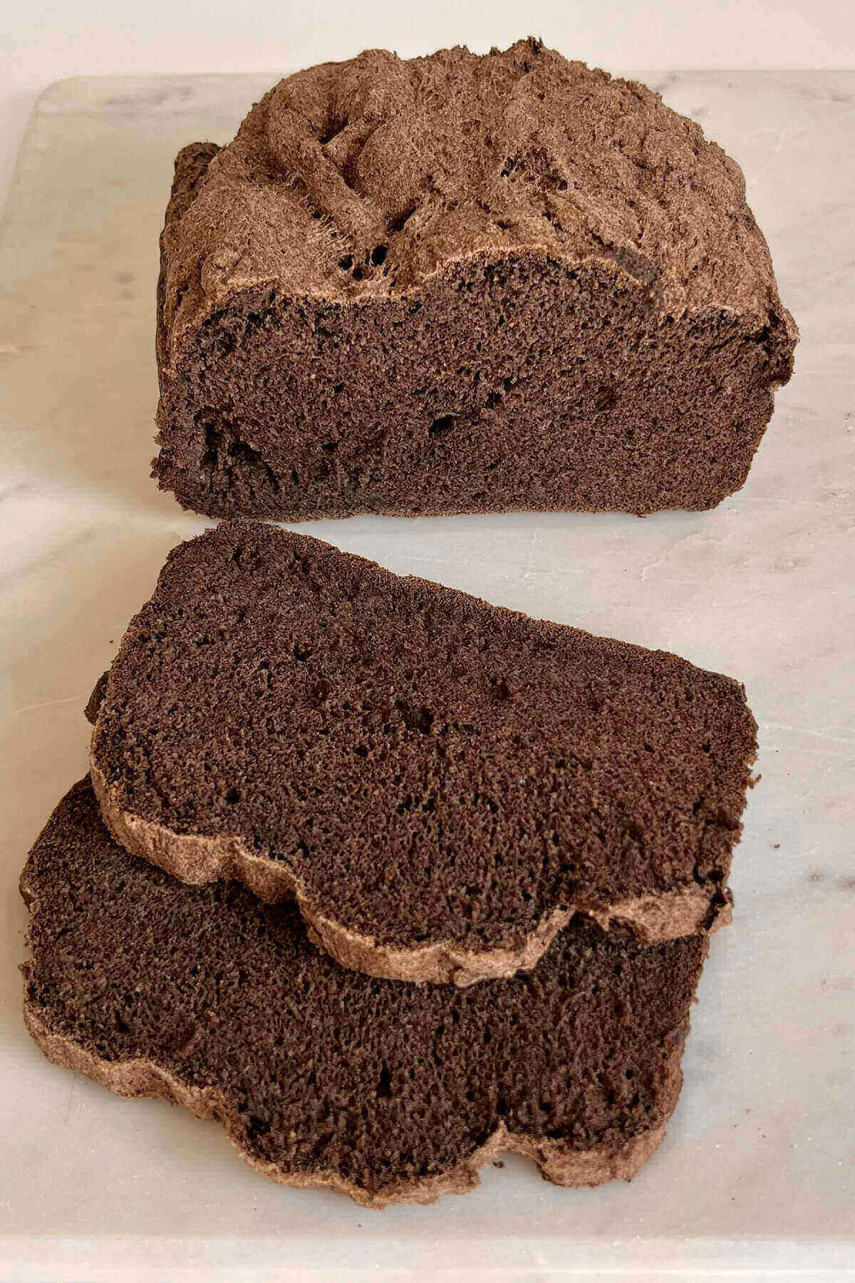 Buckwheat loaf with two slices cut on a cutting board.