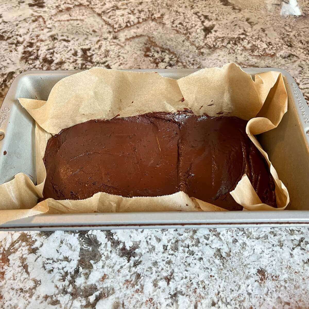 Fudge in a loaf pan lined with parchment paper.