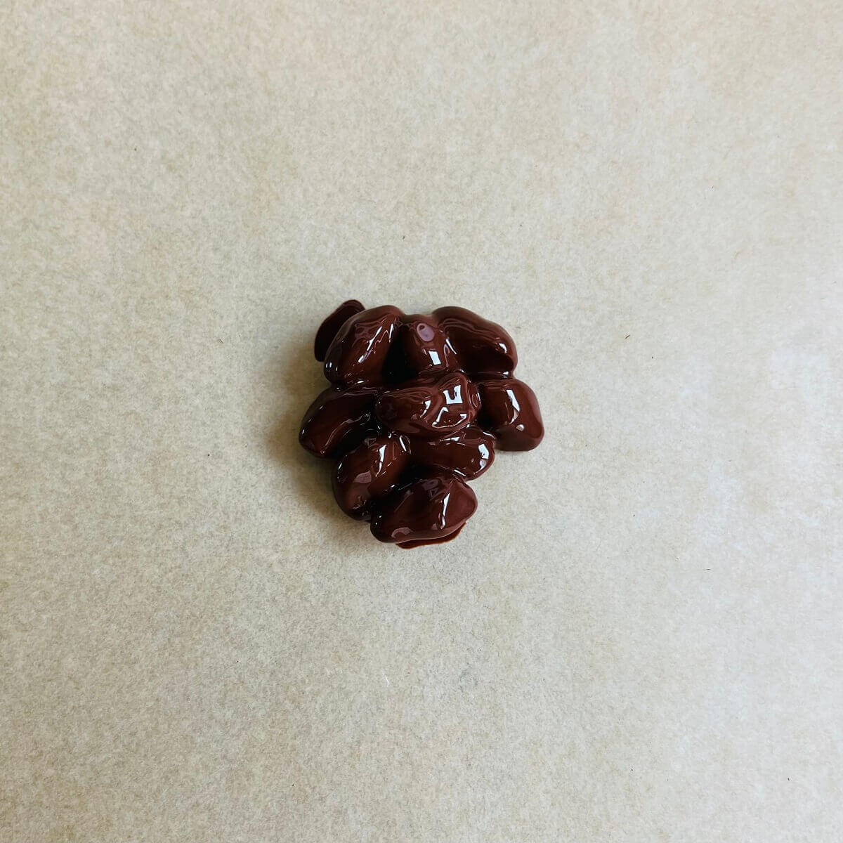 A pistachio chocolate cluster on a piece of parchment paper.