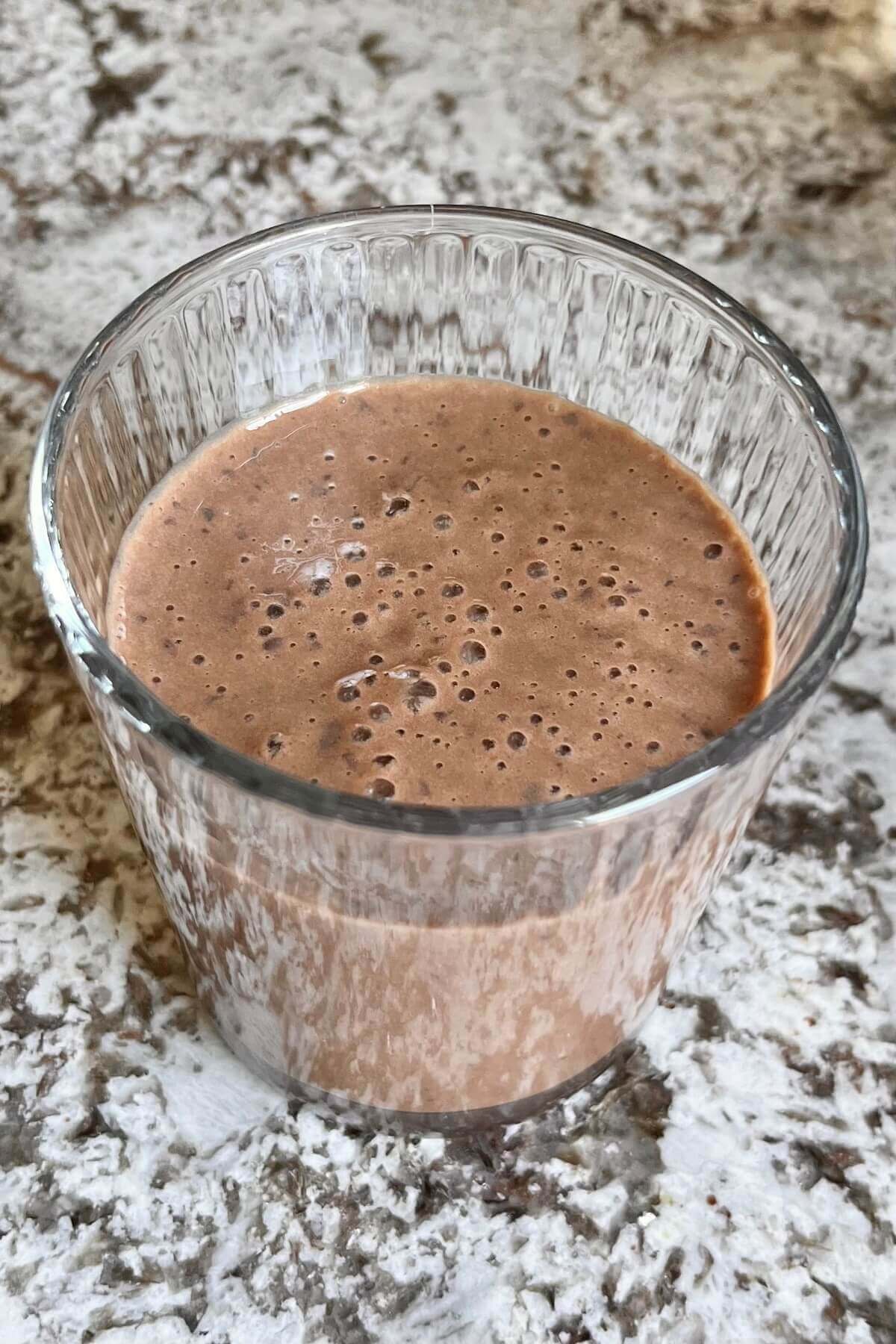 A brown, creamy smoothie in a glass.