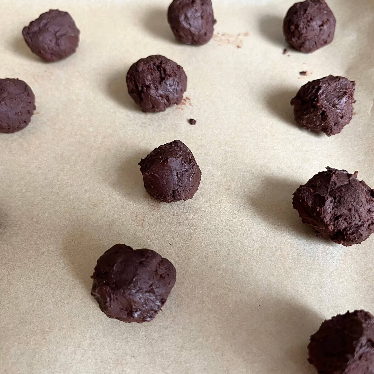 Mocha chocolate balls on a sheet pan lined with parchment paper.