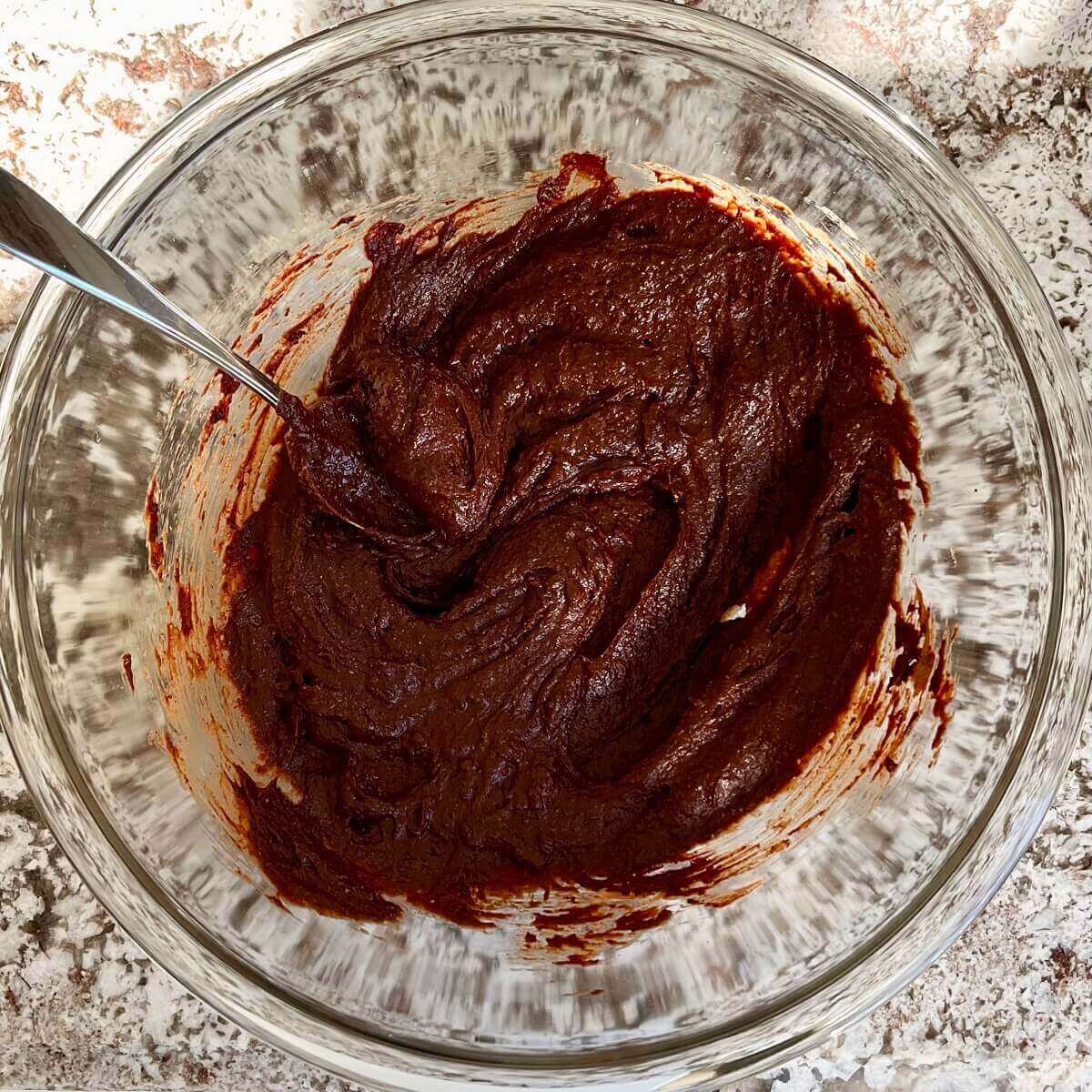 Wey ingredients for brownies in a glass mixing bowl.