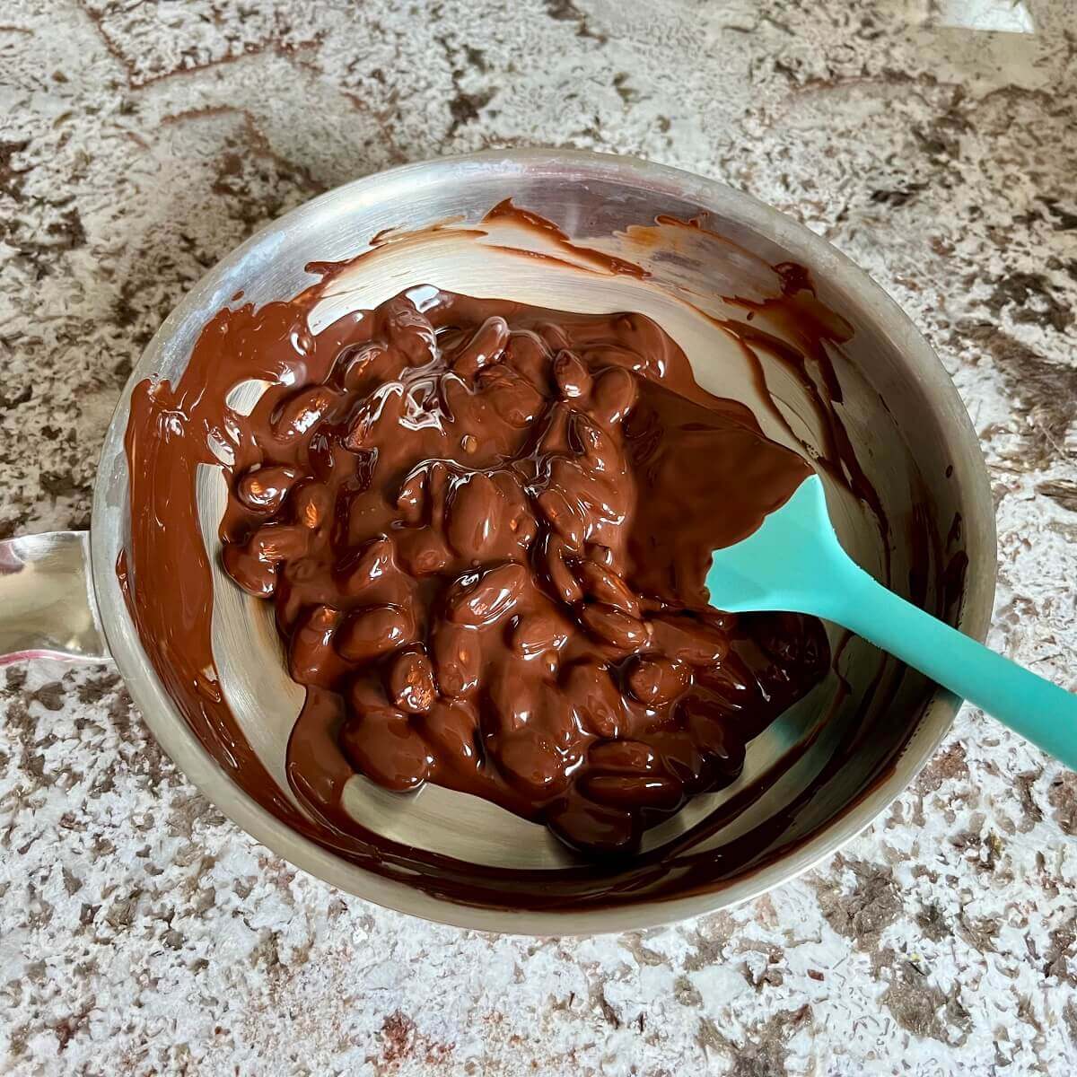 Almonds and melted chocolate in a pan.