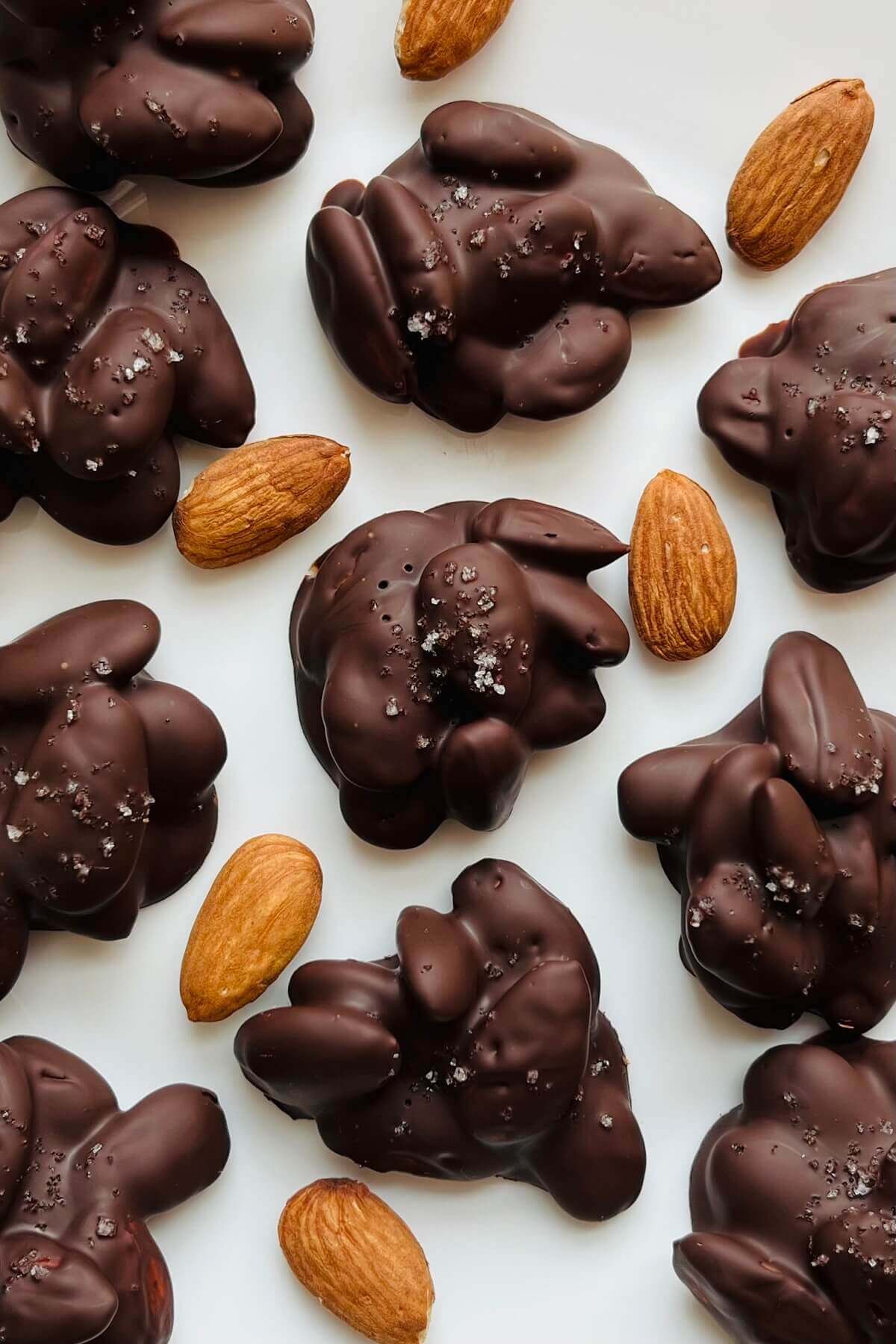 Chocolate almond clusters on a white plate.