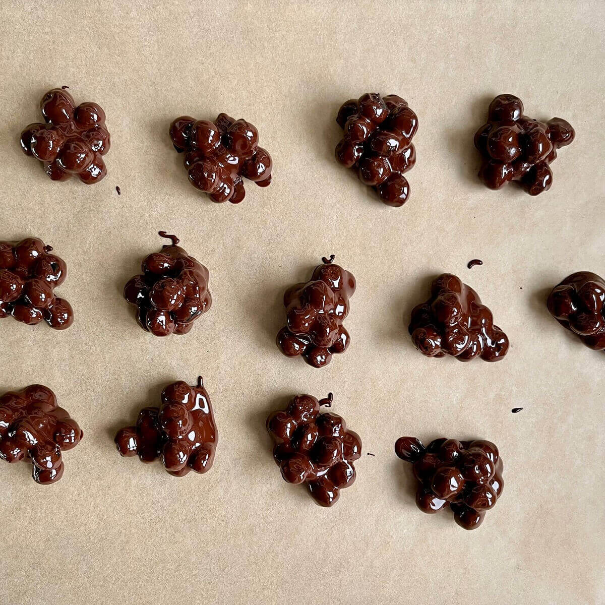 Chocolate blueberry clusters on a sheet pan lined with parchment paper.